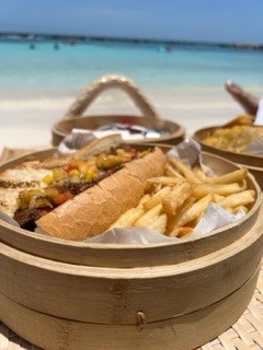 Blackened fish sandwich with fries served in a bamboo steamer