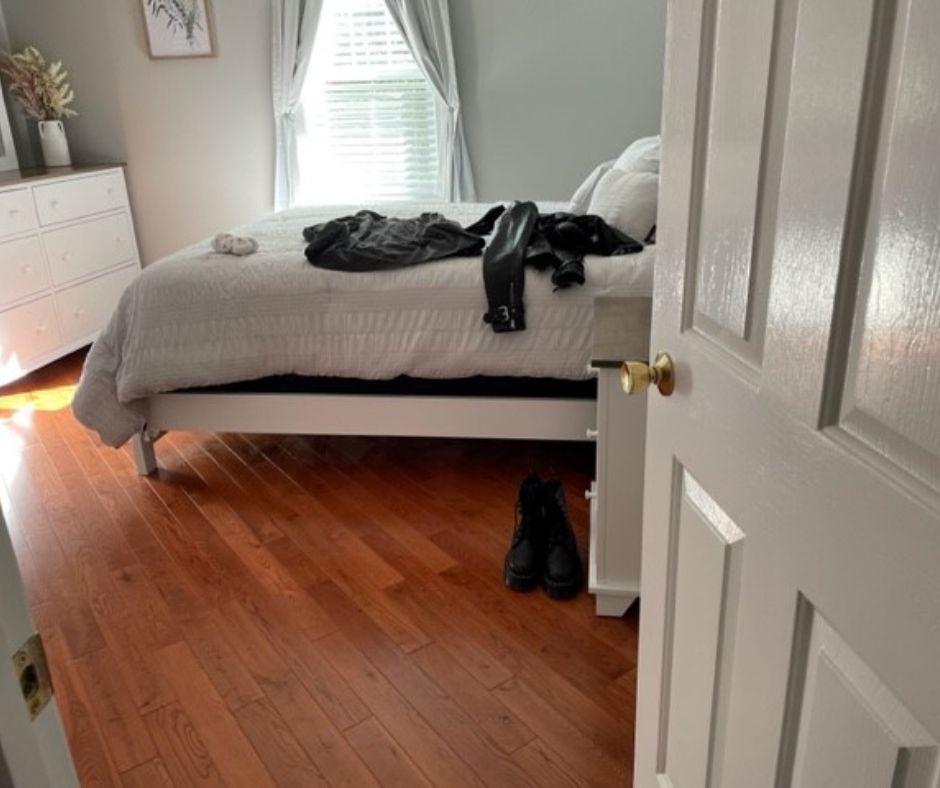Picture of an open bedroom door with clothes on the bed