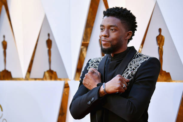 Picture of Chadwick Boseman with arms crossed in Wakanda Forever pose