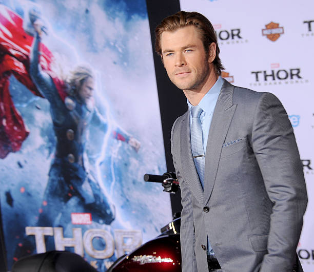 Chris Helmsworth next to a Thor The Dark World poster