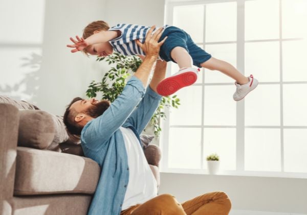 Man with beard holding up child