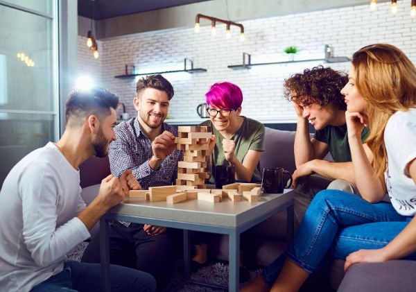 Group of five friends playing jenga