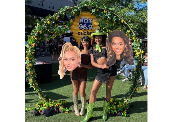 Two Beyonce fans holding cardboard cutouts of Beyonce's head