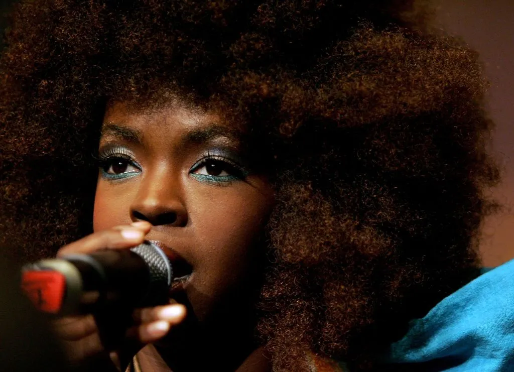 Lauryn Hill performing on stage. Close up of her face with natural hair and colorful eye makeup
