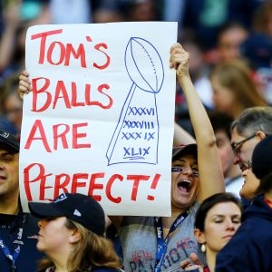 A Pats fan holds up a sign that reads Tom's balls are perfect. 