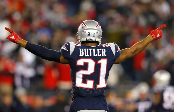 Back view of Malcolm Butler in his #21 Patriots jersey with his arms outstretched.