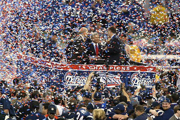 Pats owner Bob Kraft on the podium after they won the Superbowl in 2002. Screen covered in confetti