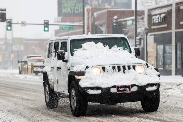 White jeep covered in show with snow still on the windshield