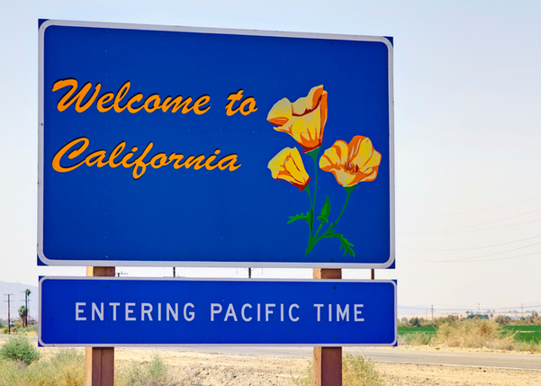 Welcome to California sign with flowers and "Entering Pacific Time" 