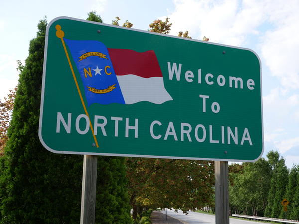 Welcome to North Carolina sign with state flag