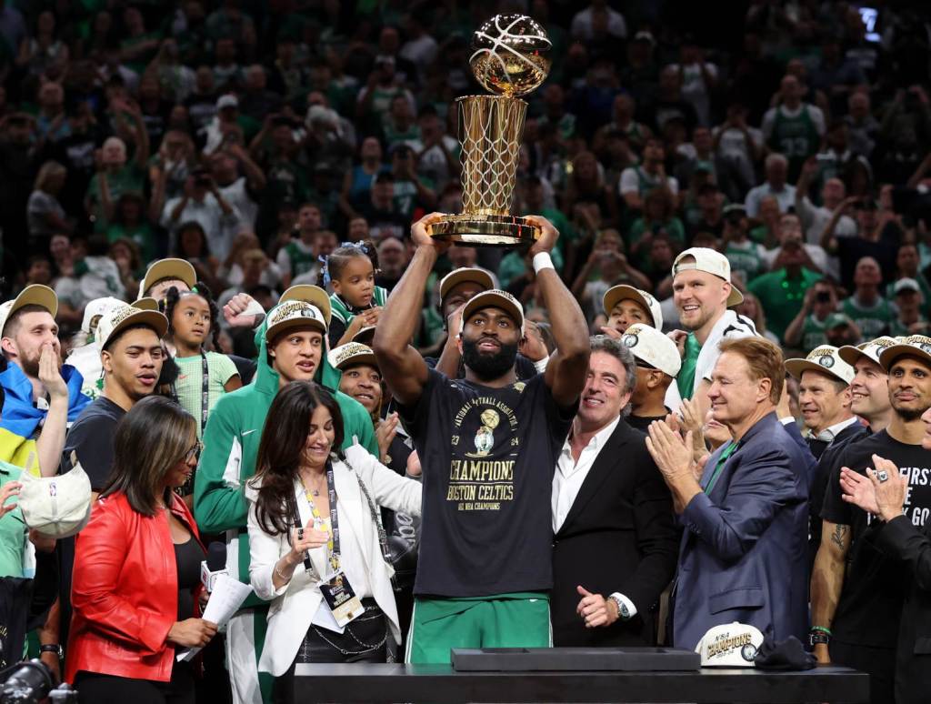 Jun 17, 2024; Boston, Massachusetts, USA; Boston Celtics guard Jaylen Brown (7) holds up the trophy after winning the 2024 NBA Finals against the Dallas Mavericks at TD Garden. Credit: Peter Casey-USA TODAY Sports